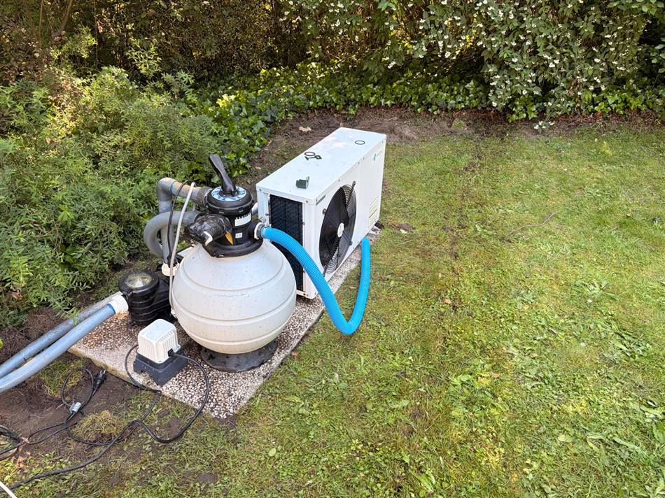Zwembadwarmtepomp met filterinstallatie op een klinkerplateau